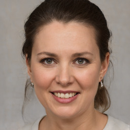 Joyful white adult female with medium  brown hair and grey eyes