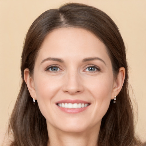 Joyful white young-adult female with long  brown hair and grey eyes