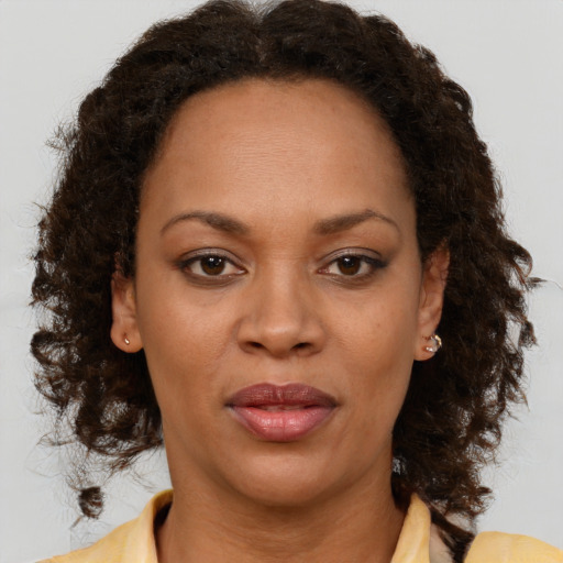 Joyful black adult female with medium  brown hair and brown eyes