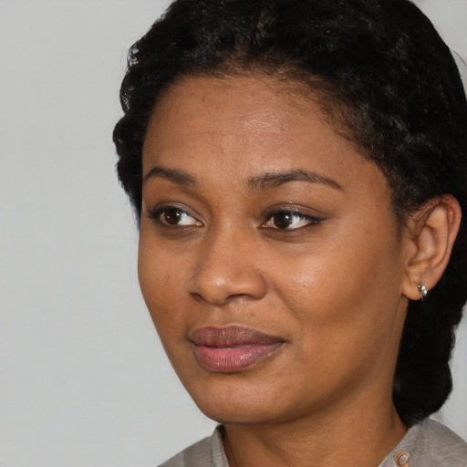 Joyful black young-adult female with short  black hair and brown eyes