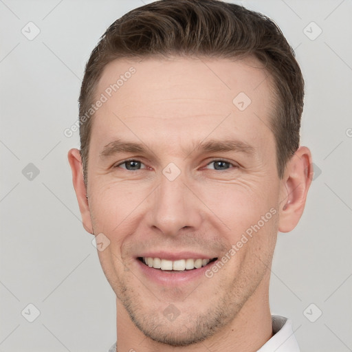 Joyful white young-adult male with short  brown hair and grey eyes