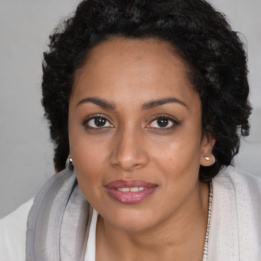 Joyful black young-adult female with long  brown hair and brown eyes