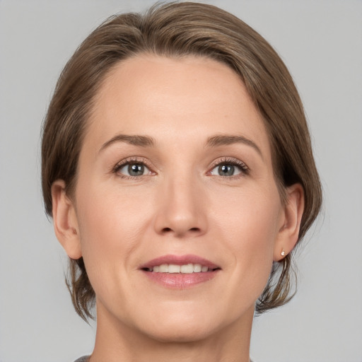 Joyful white adult female with medium  brown hair and grey eyes