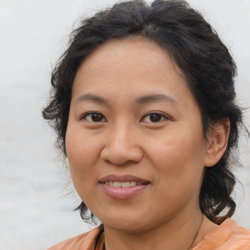 Joyful asian adult female with medium  brown hair and brown eyes