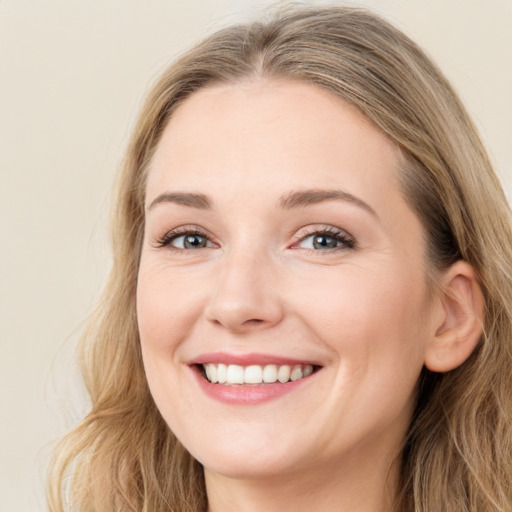 Joyful white young-adult female with long  brown hair and blue eyes