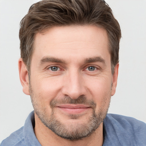 Joyful white adult male with short  brown hair and grey eyes