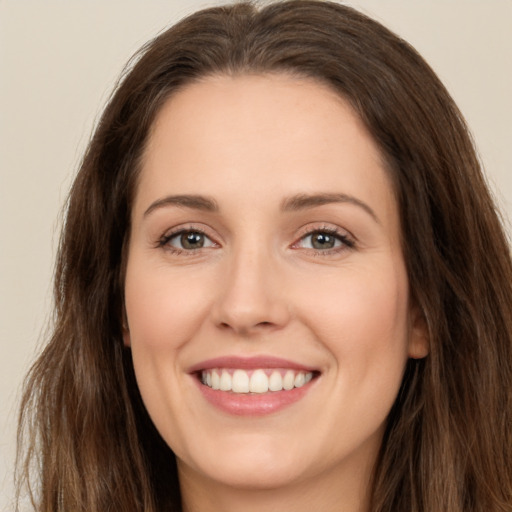 Joyful white young-adult female with long  brown hair and brown eyes