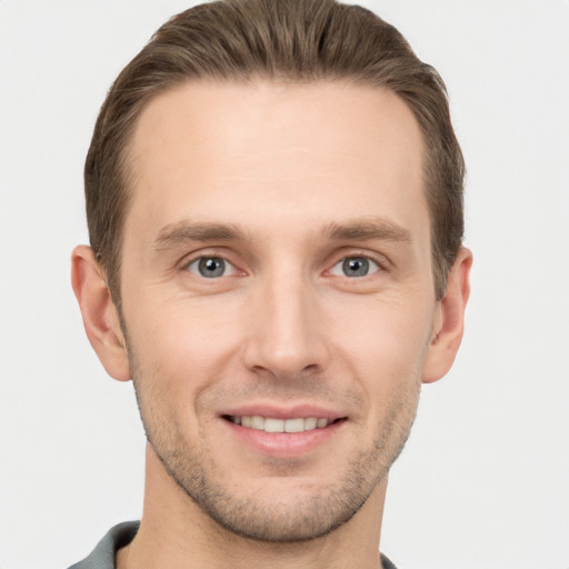 Joyful white young-adult male with short  brown hair and grey eyes