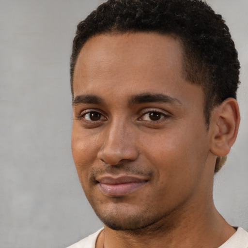 Joyful black young-adult male with short  brown hair and brown eyes