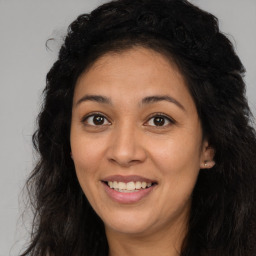 Joyful latino young-adult female with long  brown hair and brown eyes