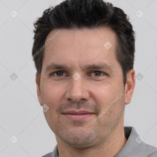 Joyful white adult male with short  black hair and brown eyes