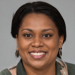 Joyful latino adult female with medium  brown hair and brown eyes