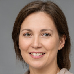 Joyful white adult female with medium  brown hair and brown eyes