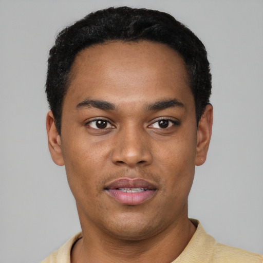 Joyful black young-adult male with short  black hair and brown eyes