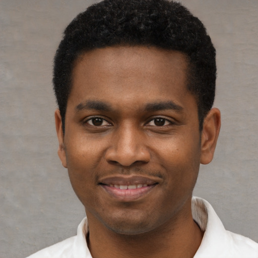 Joyful black young-adult male with short  black hair and brown eyes