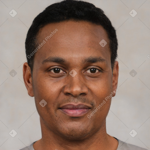 Joyful black young-adult male with short  black hair and brown eyes