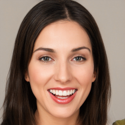 Joyful white young-adult female with long  brown hair and brown eyes