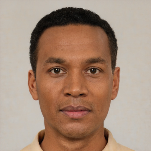 Joyful black young-adult male with short  black hair and brown eyes
