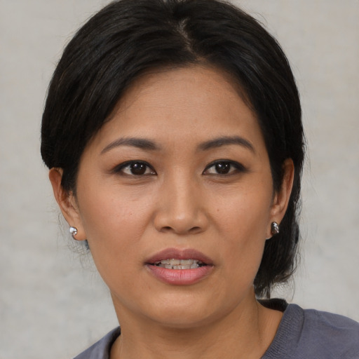 Joyful asian adult female with medium  brown hair and brown eyes