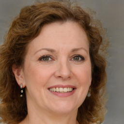 Joyful white adult female with medium  brown hair and green eyes