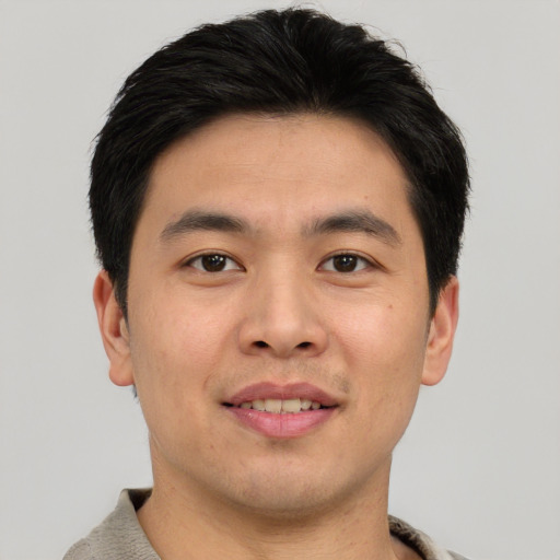 Joyful asian young-adult male with short  brown hair and brown eyes