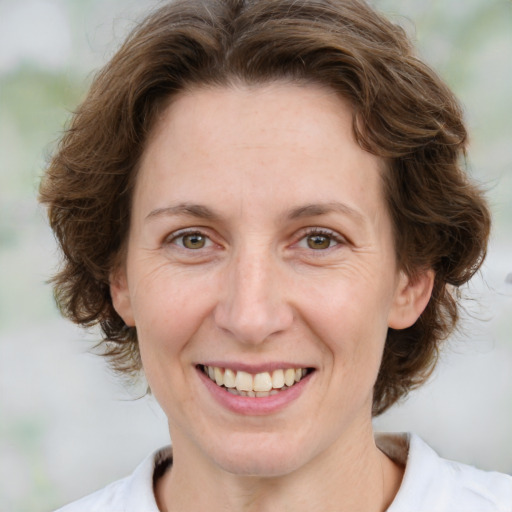 Joyful white young-adult female with medium  brown hair and green eyes