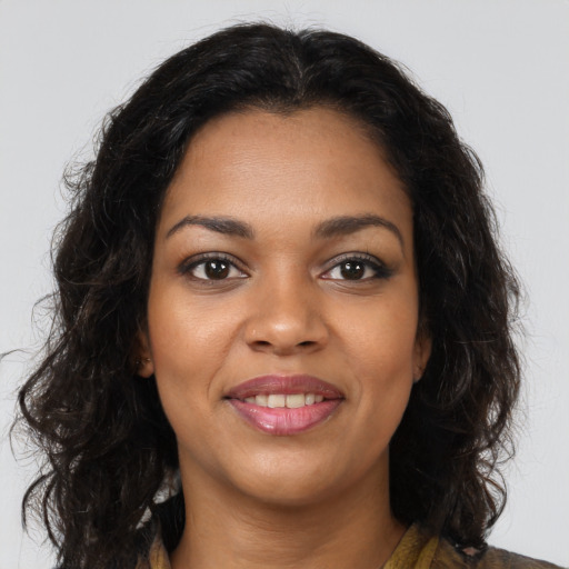 Joyful black young-adult female with long  brown hair and brown eyes