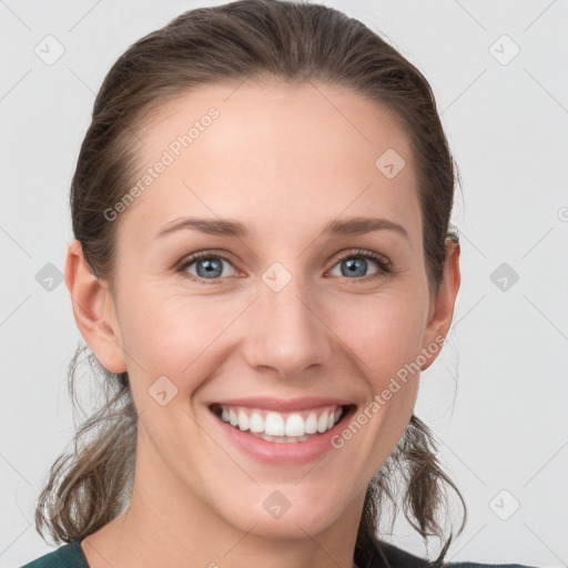 Joyful white young-adult female with medium  brown hair and grey eyes