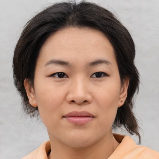 Joyful asian young-adult female with medium  brown hair and brown eyes