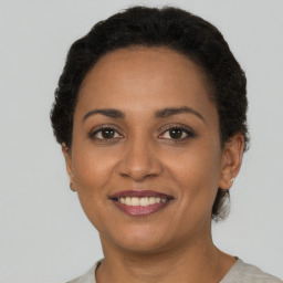 Joyful black young-adult female with short  brown hair and brown eyes