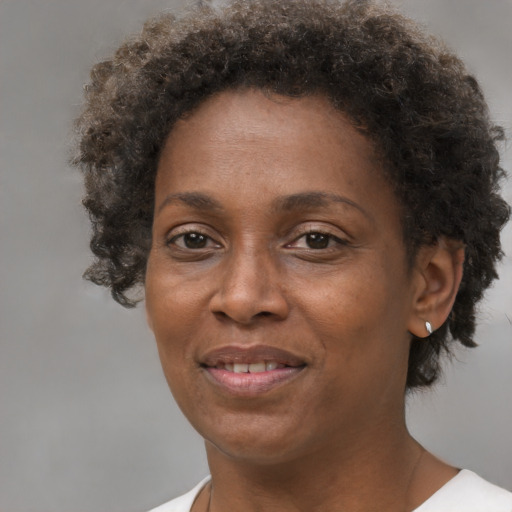 Joyful black adult female with short  brown hair and brown eyes