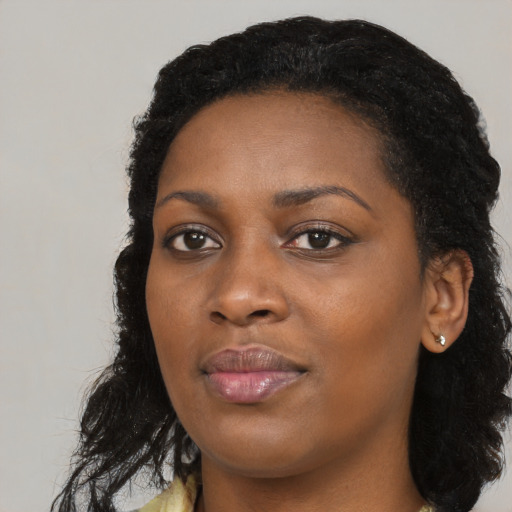 Joyful black young-adult female with long  black hair and brown eyes