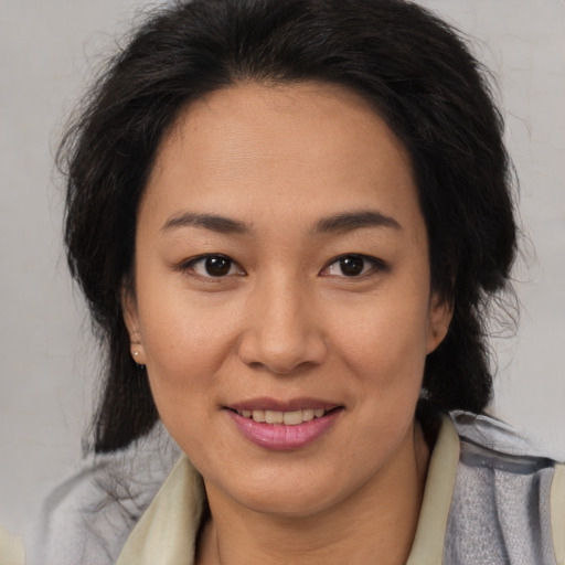 Joyful latino adult female with medium  brown hair and brown eyes