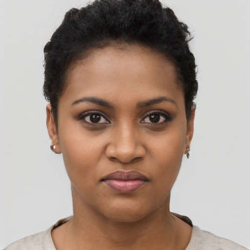 Joyful black young-adult female with short  black hair and brown eyes