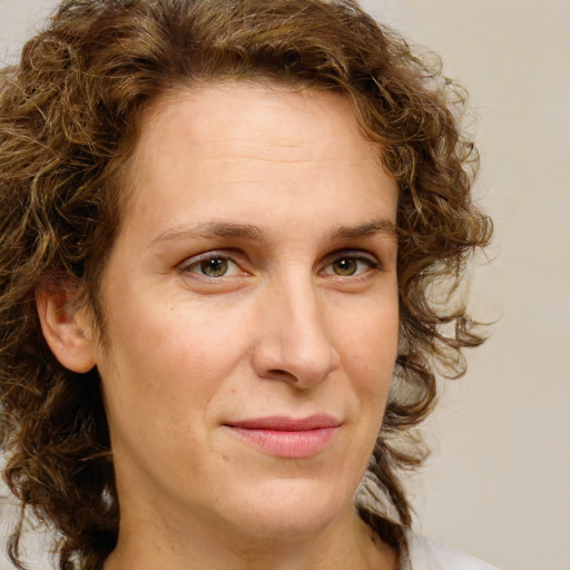 Joyful white adult female with medium  brown hair and green eyes