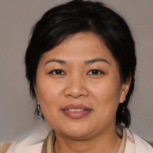 Joyful asian adult female with medium  brown hair and brown eyes