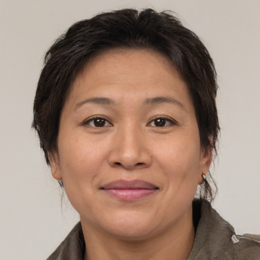 Joyful asian adult female with medium  brown hair and brown eyes