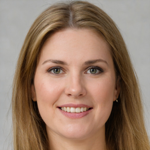 Joyful white young-adult female with long  brown hair and green eyes