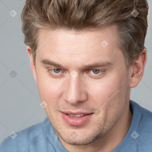 Joyful white adult male with short  brown hair and blue eyes