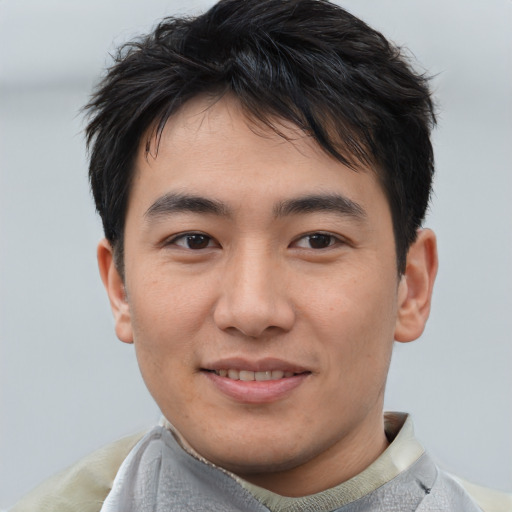 Joyful asian young-adult male with short  black hair and brown eyes