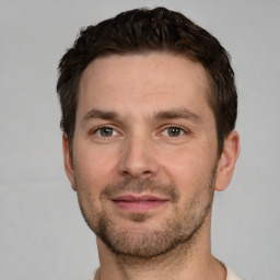 Joyful white young-adult male with short  brown hair and grey eyes