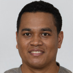 Joyful black young-adult male with short  black hair and brown eyes