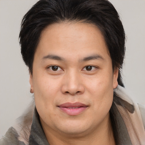 Joyful asian young-adult male with medium  brown hair and brown eyes