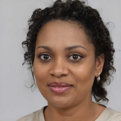 Joyful black adult female with medium  brown hair and brown eyes