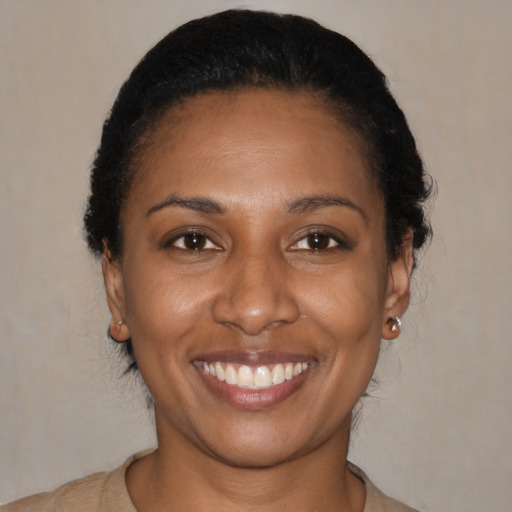 Joyful black young-adult female with short  black hair and brown eyes