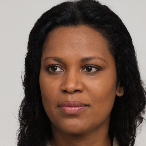 Joyful black young-adult female with long  black hair and brown eyes