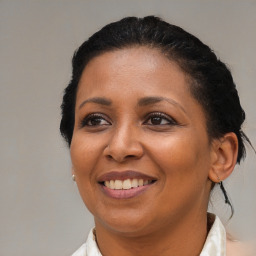 Joyful black young-adult female with medium  brown hair and brown eyes