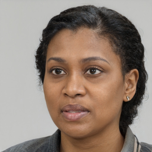 Joyful black young-adult female with medium  black hair and brown eyes