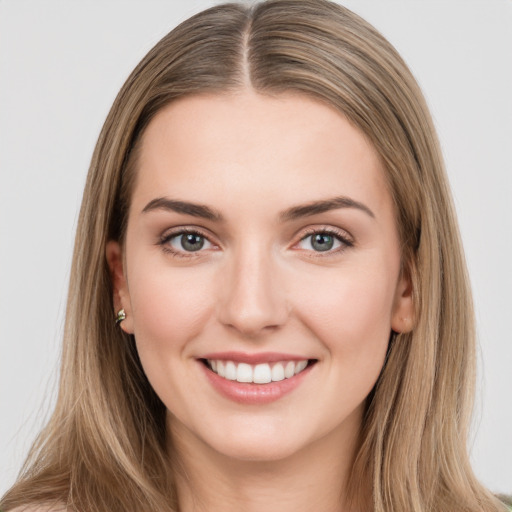 Joyful white young-adult female with long  brown hair and green eyes