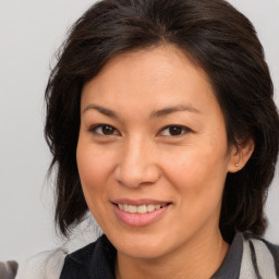 Joyful white adult female with medium  brown hair and brown eyes